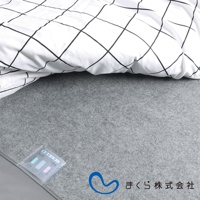 淺灰色備長炭防潮床墊，表面鋪有白色格紋床單，左下角有濕度感測器標籤。