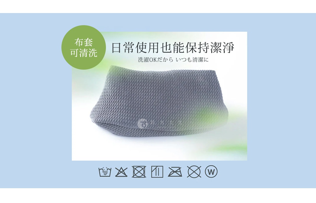 一張Amaze plus眼部舒壓枕的宣傳圖片，主體為一個灰色編織紋理的長條狀枕頭，背景為淡藍色。上方圓形綠色標籤文字為布套可清洗，中間主標題為日常使用也能保持潔淨，並附有相關的日文說明與洗滌注意事項的圖示標誌。