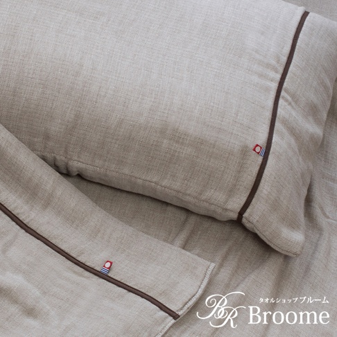 米白色今治五層紗枕套，帶有深棕色滾邊，枕套一角有藍、白、紅三色織標。