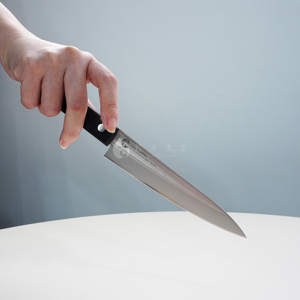 人手持一把燕三條 VG-10 不鏽鋼水果刀，刀刃為銀色金屬光澤，刀柄為黑色。