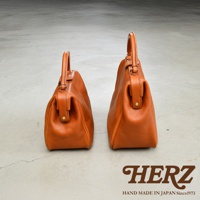 兩款不同尺寸的職人手作皮革Organ方形口金托特包，皆為棕褐色，圓潤的包身配備提把與金屬釦。