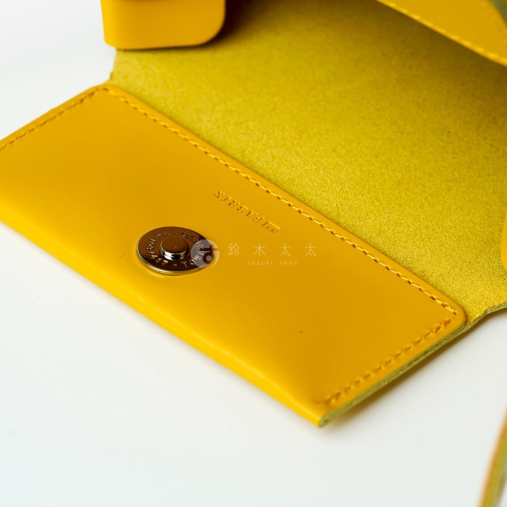FABRIK 皮革迷你斜背包的黃色內裡，特寫磁釦及 SUZUKI SHOP 文字商標