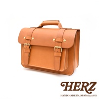 職人手作皮革經典雙扣兩用單肩包，呈現自然鞣製的棕褐色皮革，配有黃銅色雙扣和縫線細節，設計簡約實用。