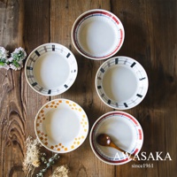 五個白色陶瓷盤，盤緣飾有格紋圖案，包含紅色、藍色、黑色和棕色線條，其中一個盤子內放有木製湯匙。