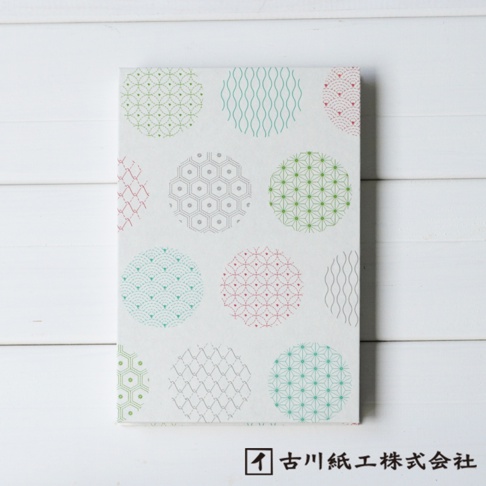 一疊美濃和紙製成的御朱印帳，封面以白色為底，印有綠色、粉紅色、藍綠色及灰色等不同顏色的圓形吉祥圖案，包含波浪紋、麻葉紋、龜甲紋等多種日式傳統紋樣。