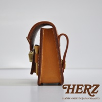 職人手作皮革高爾夫腰包，採用天然皮革材質，呈現溫潤的棕色調，側面有精緻的縫線，金屬扣環點綴，設計簡約實用。