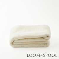 摺疊的單人美麗諾羊毛保暖墊，呈現米白色，材質柔軟厚實，適合保暖。