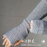 一雙灰色、網狀編織的輕柔有機棉遮陽袖套，帶有流蘇裝飾，覆蓋手部至手肘。