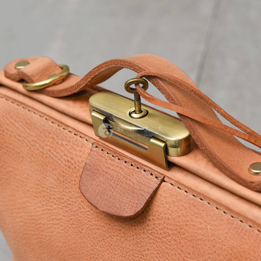 HERZ Organ 鎖孔式肩背包的皮革細節，配有鑰匙和復古銅色鎖扣。