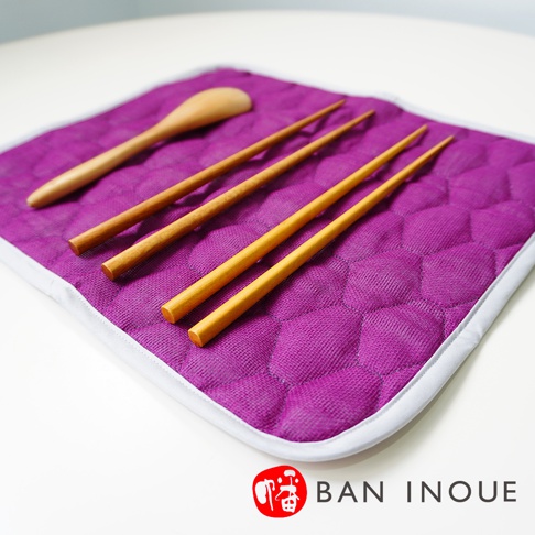 紫色菱格紋布料吸水墊，上方擺放著一支木勺和四雙木筷。