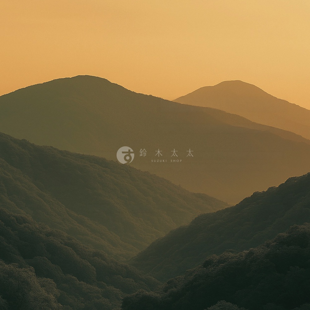 在溫暖柔和的金色晨曦照耀下，層巒疊嶂的山脈呈現出深淺不一的剪影，遠處山峰隱沒在朦朧的霧氣中，中央處飾有鈴木太太 Suzuki Shop 的品牌標誌，整體畫面氛圍靜謐且充滿禪意。