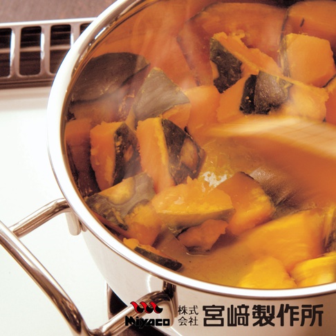 GEO無水料理萬能鍋-雙耳湯鍋，鍋內盛有烹煮中的南瓜塊，湯汁呈橘黃色，鍋身為不鏽鋼材質，鍋邊有雙耳設計。