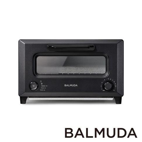 黑色 BALMUDA ReBaker 烤麵包機，配有金屬外殼、玻璃門和兩個控制旋鈕，一個用於模式選擇，另一個用於定時。