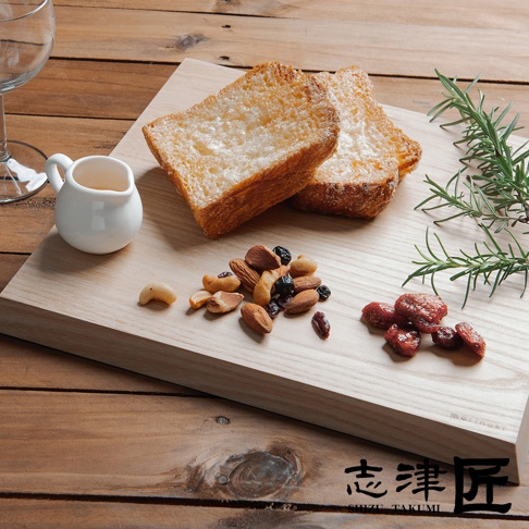 morinoki / Cutting board 榆木砧板-S 上的兩塊烤吐司、一小碟堅果和幾顆乾果，旁邊放著一株迷迭香，右下角有「志津匠」和「SHIZU TAKUMI」的品牌標誌。