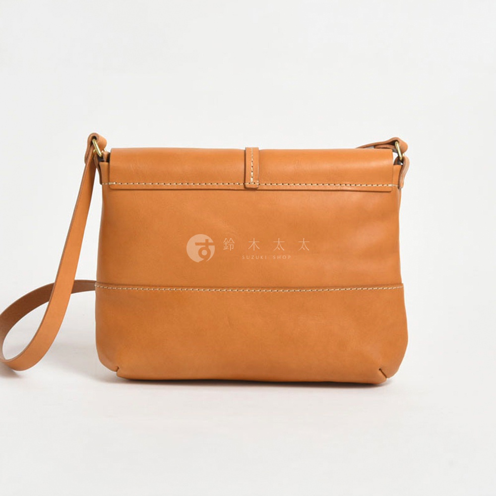 一個淺棕色的皮革斜背包，有縫線和磁釦設計