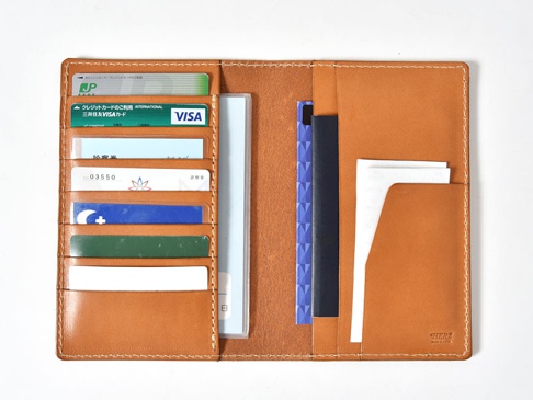 職人手作皮革多用途收納長夾，採用棕色皮革製成，內部有多個卡槽，可放置多張信用卡、證件或票券，並有文件夾層，設計簡潔實用。