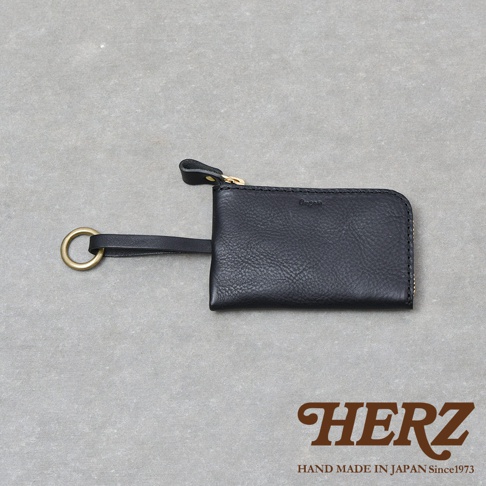 日本HERZ職人手作黑色皮革鑰匙包，外觀採用帶有紋理的Minerva Box皮革製成，配置黃銅色金屬拉鍊與圓形掛環，底部右下角印有Organ品牌壓印標誌，整體呈現極簡質感風格。