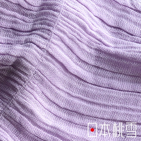 一張近距離拍攝的日本桃雪品牌淡紫色純棉紗布圍巾細節圖，布料呈現自然的波浪狀皺褶，展現出棉質紗布透氣且輕盈的柔軟質感。