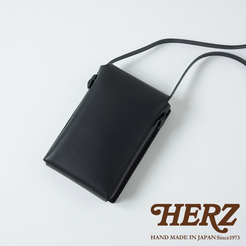 黑色皮革手機包，有細長肩帶，可斜背，包身簡約，做工精緻。