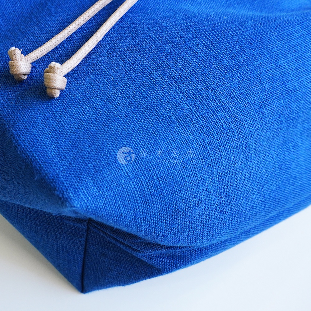 BAN INOUE 麻花辮束口手提包 藍色，近景拍攝，聚焦於麻繩束口細節與包包的藍色織物材質。