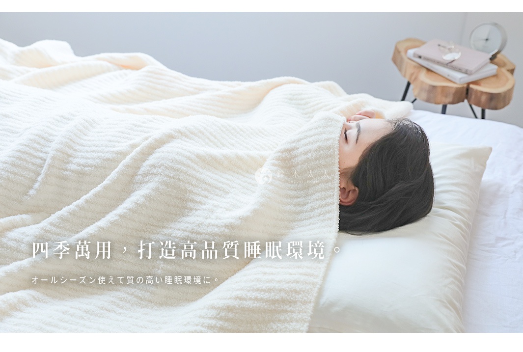 一床米白色、表面有細緻條紋紋理的柔暖毯，覆蓋在一位側臥的女性身上，她臉部露出，頭髮散落在枕頭上。