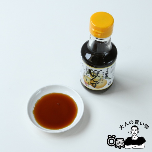 玻璃瓶裝森文柑橘醋調味料，黃色瓶蓋，醬汁呈深褐色，旁邊有一小碟同樣顏色的液體。