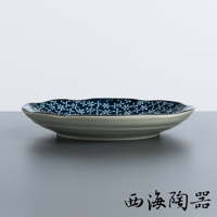 日本美濃燒古典菊造型大圓盤，藍色釉面飾以白色小花圖案，盤緣呈現波浪狀，盤身為淺灰色，質地為陶瓷。