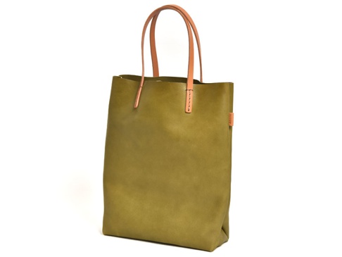 橄欖綠色軟皮直式托特包，配有棕色皮革提把，包身簡約，左側有橘色品牌標籤。