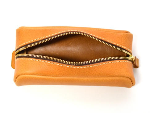 淺棕色皮革圓角筆袋，拉鍊部分敞開，露出內部空間。袋身縫線明顯，拉鍊頭為金色。