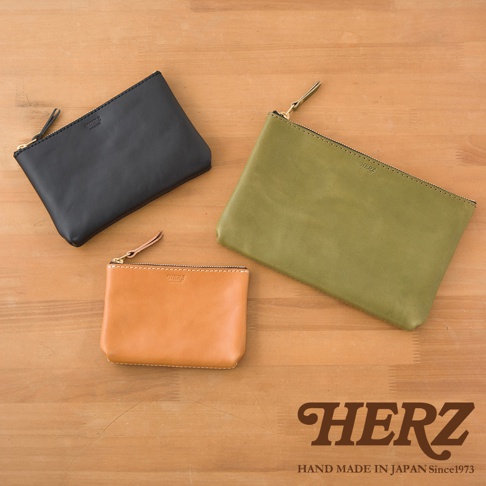 三款職人手作皮革長方形拉鍊收納包，顏色分別為黑色、橄欖綠及原色皮革，皆配有金色拉鍊與同色系皮革拉頭，展現簡約質感。