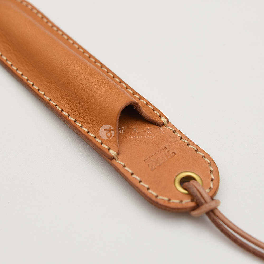 職人手作皮革掛繩筆套，淺棕色皮革，縫線精緻，附有金屬環及繫繩。
