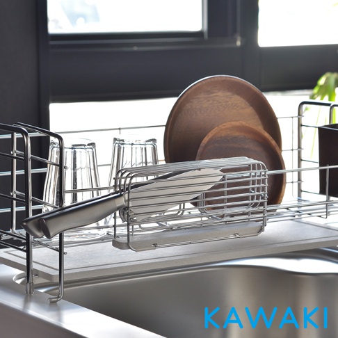 銀色金屬網架上，放置著一個刀架，刀架內有一把銀色刀柄的刀。架子後方有兩個透明玻璃杯和兩個木製圓盤。