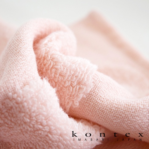 粉色紗布浴巾與柔膚方巾特寫，細緻的織紋與柔軟的毛圈質地清晰可見，適合寶寶的溫和觸感。