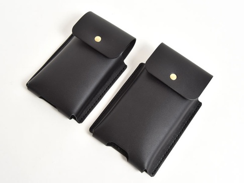 兩個職人手作黑色皮革三用手機收納包，帶有金色按扣，材質為皮革，縫線整齊。