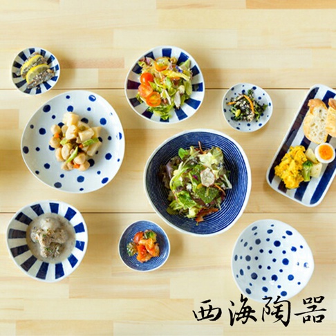 白色陶瓷小菜碟，點綴著藍色圓點圖案，搭配藍白條紋邊緣，呈現日式簡約風格，適合盛裝多樣小菜。