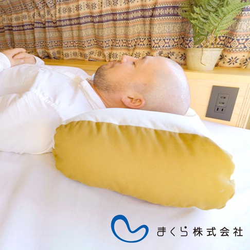 JOURNEY 旅行便攜枕，黃色布套搭配白色布套，枕頭呈長條狀，一位男性仰臥使用，背景為床鋪與裝飾布簾。