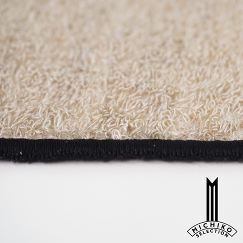一張近拍的毛巾局部，上面有黑色的邊緣，下方是一個「MICHI KO SELECTION」的標誌。