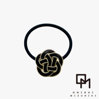 黑色髮圈搭配精緻的日式水引花結裝飾，花結以黑色繩線編織，邊緣點綴金絲，呈現立體層次感。