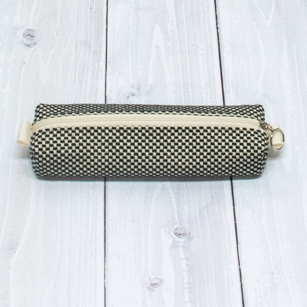 黑白格紋三河木綿刺子織筆袋，配有米白色拉鍊及金色拉環，側面有米白色布環。