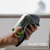 一雙手正使用深灰色超細纖維擦拭布擦拭一個綠色玻璃杯，杯上有水珠。