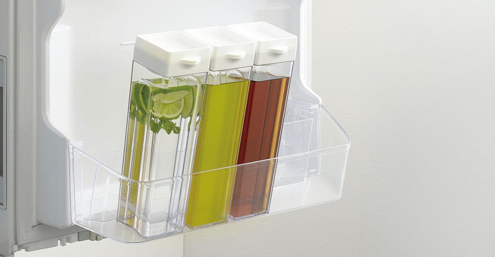 Pearl Life 直橫放冰箱冷水壺，內含三瓶飲料，其中一瓶加入檸檬片和薄荷葉，另外兩瓶分別是黃色和紅褐色液體，放置於透明冰箱置物架上。