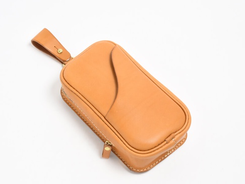 職人手作皮革兩用直立型斜背包，呈現天然淺棕色皮革，包身縫線清晰，配有金色拉鍊及皮革提帶。