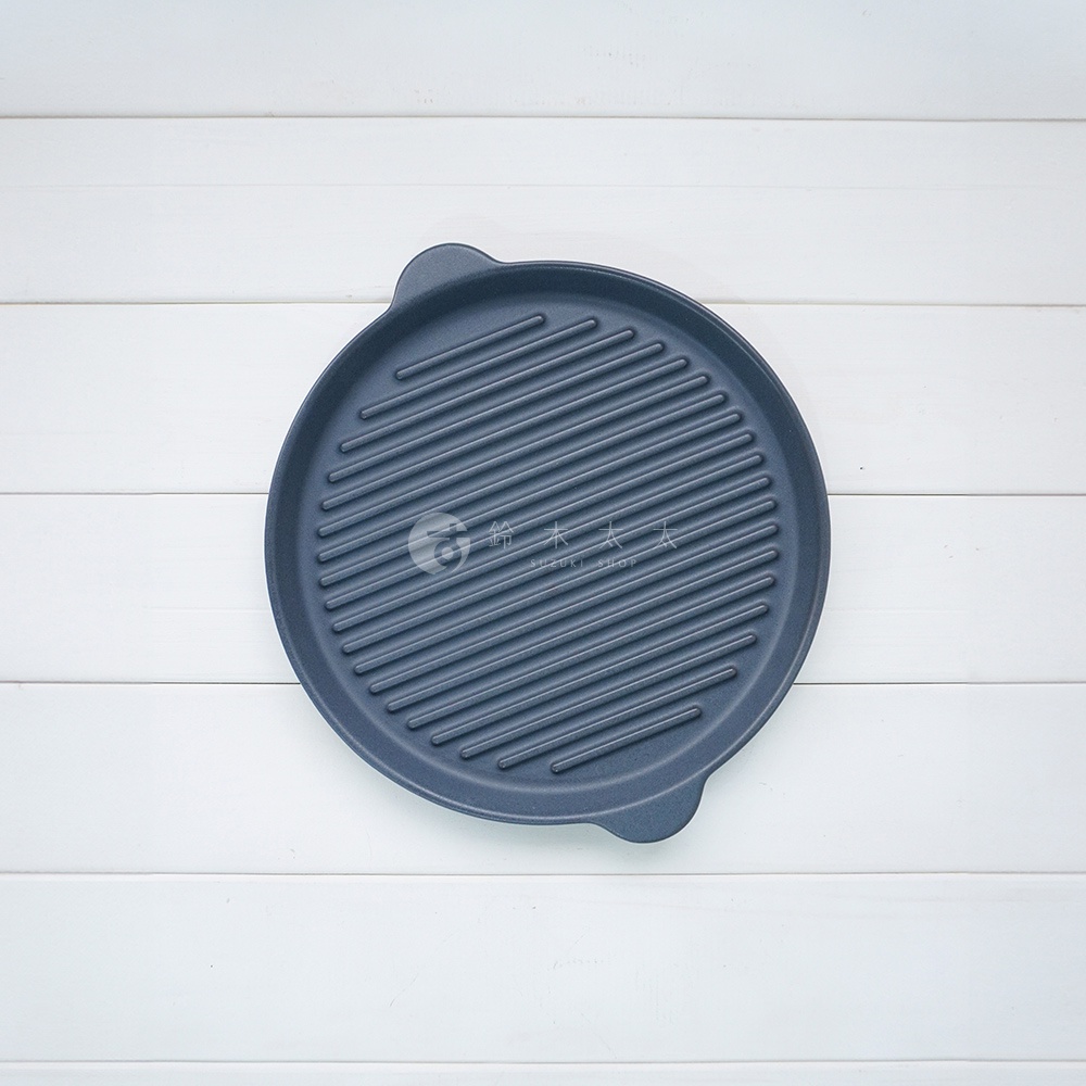 深藍色圓形陶製烤盤，表面有均勻的波浪紋理，兩側有提把，適合烤肉或烘烤。