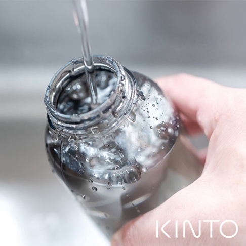 透明塑膠水瓶，瓶身佈滿水珠，正被注入清水。瓶蓋為銀色金屬材質，瓶身下方可見品牌標誌KINTO。