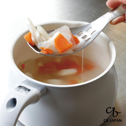 CB JAPAN 日本製不鏽鋼原子設計瀝湯勺，正在從鍋中撈起胡蘿蔔和白蘿蔔塊，湯汁透過勺子上的孔洞瀝出。