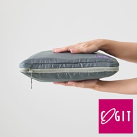 一雙手正拿著一個灰色的折疊壓縮旅行袋，袋子為扁平狀，拉鍊處有淺灰色滾邊，袋子上印有紫色標籤。