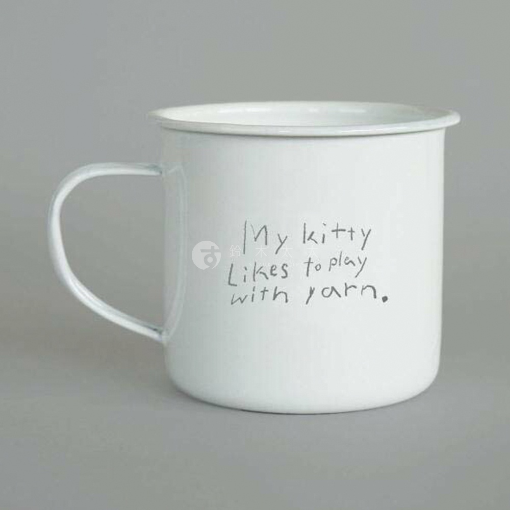 白色琺瑯馬克杯，杯身印有手寫英文「My kitty likes to play with yarn.」，配有銀色金屬把手。