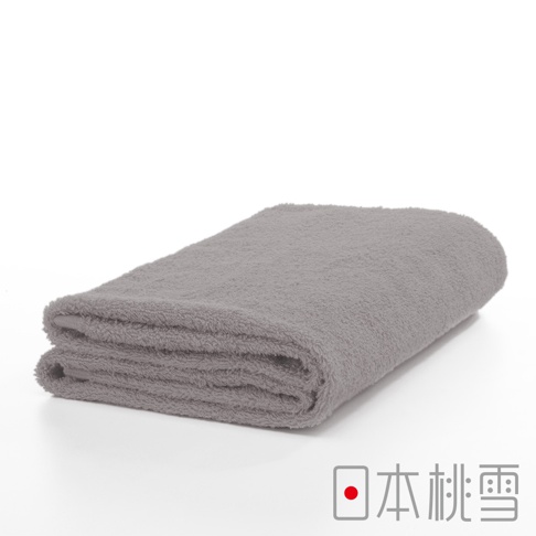 一張摺疊的灰色精梳棉飯店浴巾，材質柔軟，邊緣有明顯的毛圈，背景為純白色。