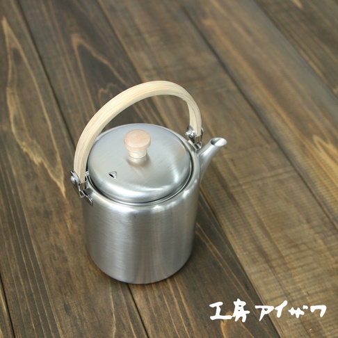 霧面不鏽鋼直筒茶壺，帶有木質提把和圓形木質壺蓋旋鈕，壺身簡潔，底部有四個金屬支腳。