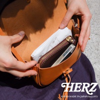 棕色皮革流蘇側背包，內有拉鍊口袋，可放置手機，材質為真皮，手工製作，風格簡約。